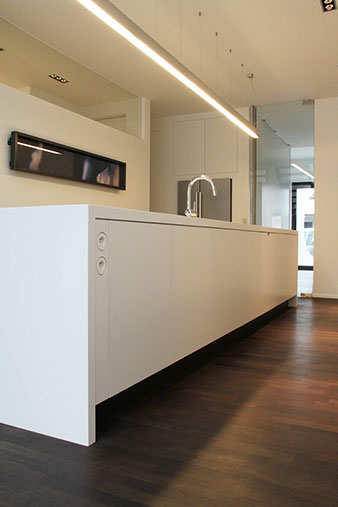 Kookeiland en wandkasten in solid surface en wit gelakte MDF