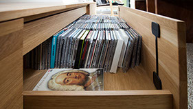 Mediameubel met detail van een lade voor Cd's, Dvd's en boeken 