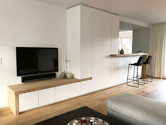 Strakke design wandkast met tv en toogmeubel aan open keuken